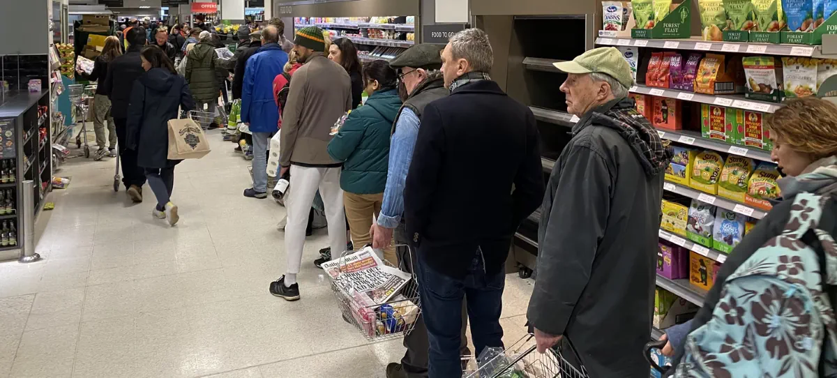 A queue of shoppers in a grocery store