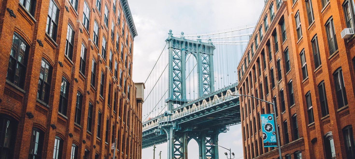 A bridge in the background is prominently visible between two similar buildings