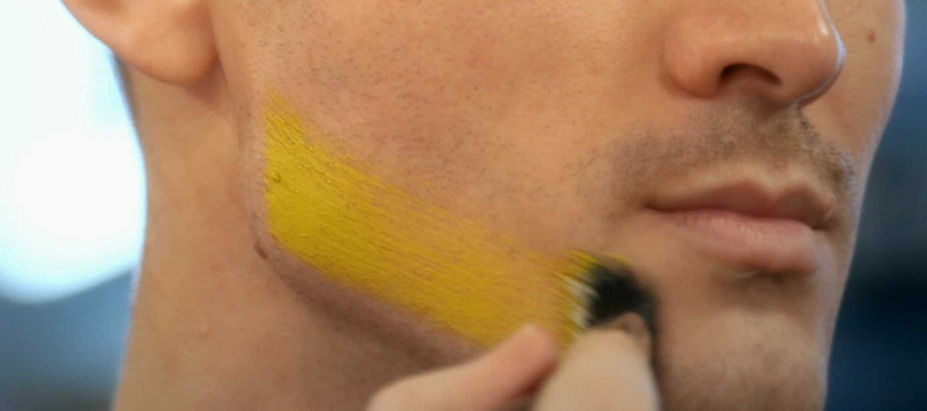 MUA applying colour along the jaw line