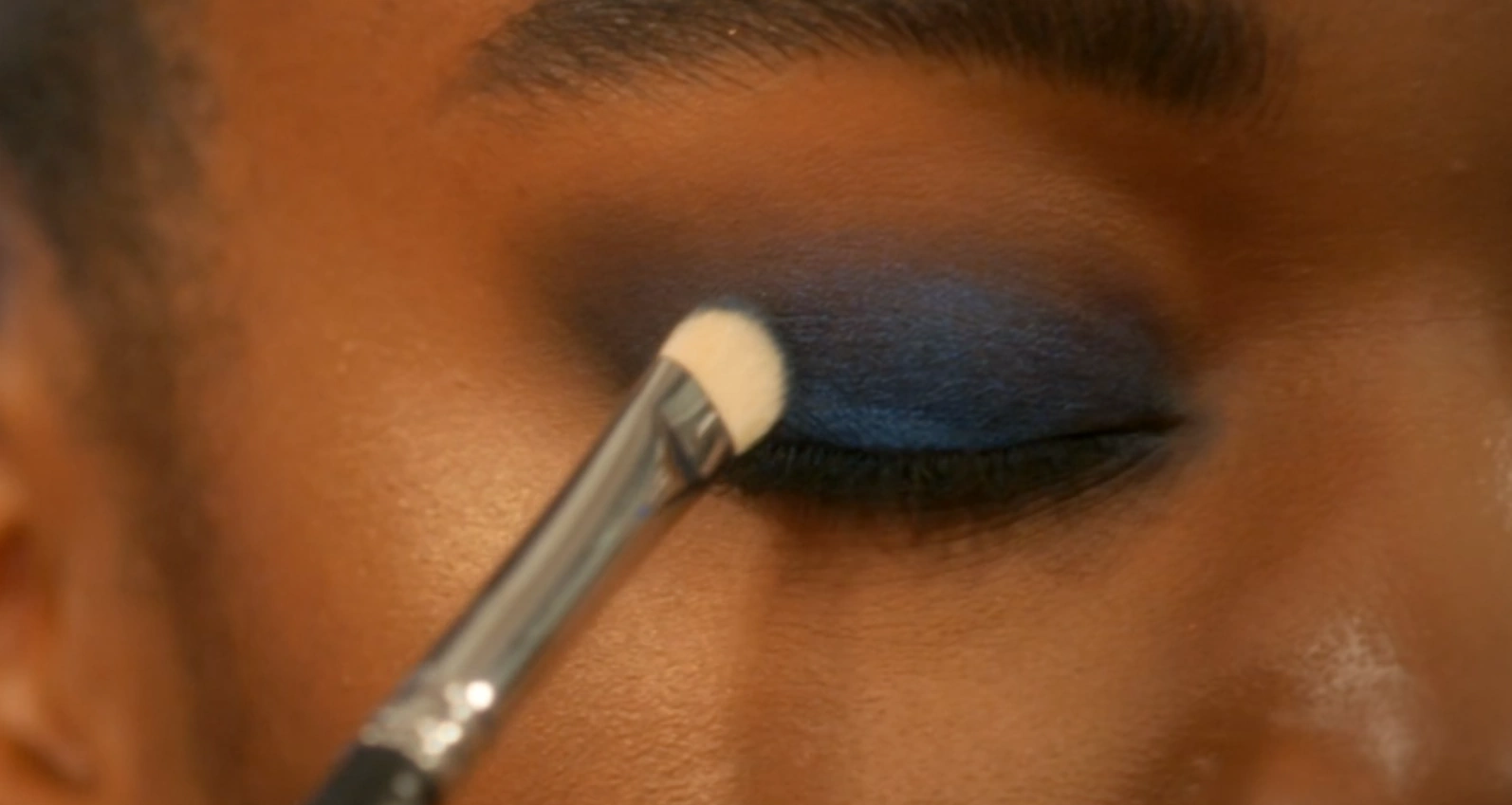 MUA adding blue colour to the eyelid