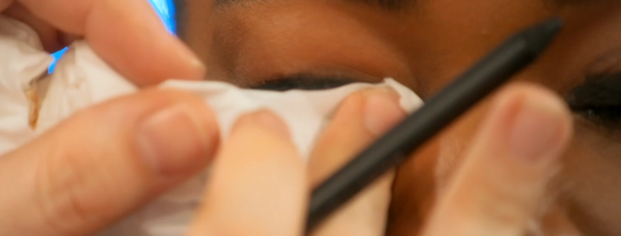 MUA smudging the black eyeliner into the socket